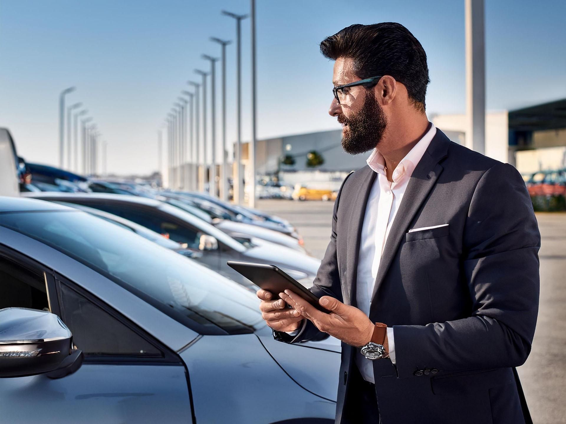 Fleet manager con tablet in mano che guarda la flotta aziendale. Foto generata con IA (Firefly)