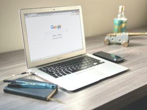 laptop su scrivania con schermata aperta dell'homepage di Google